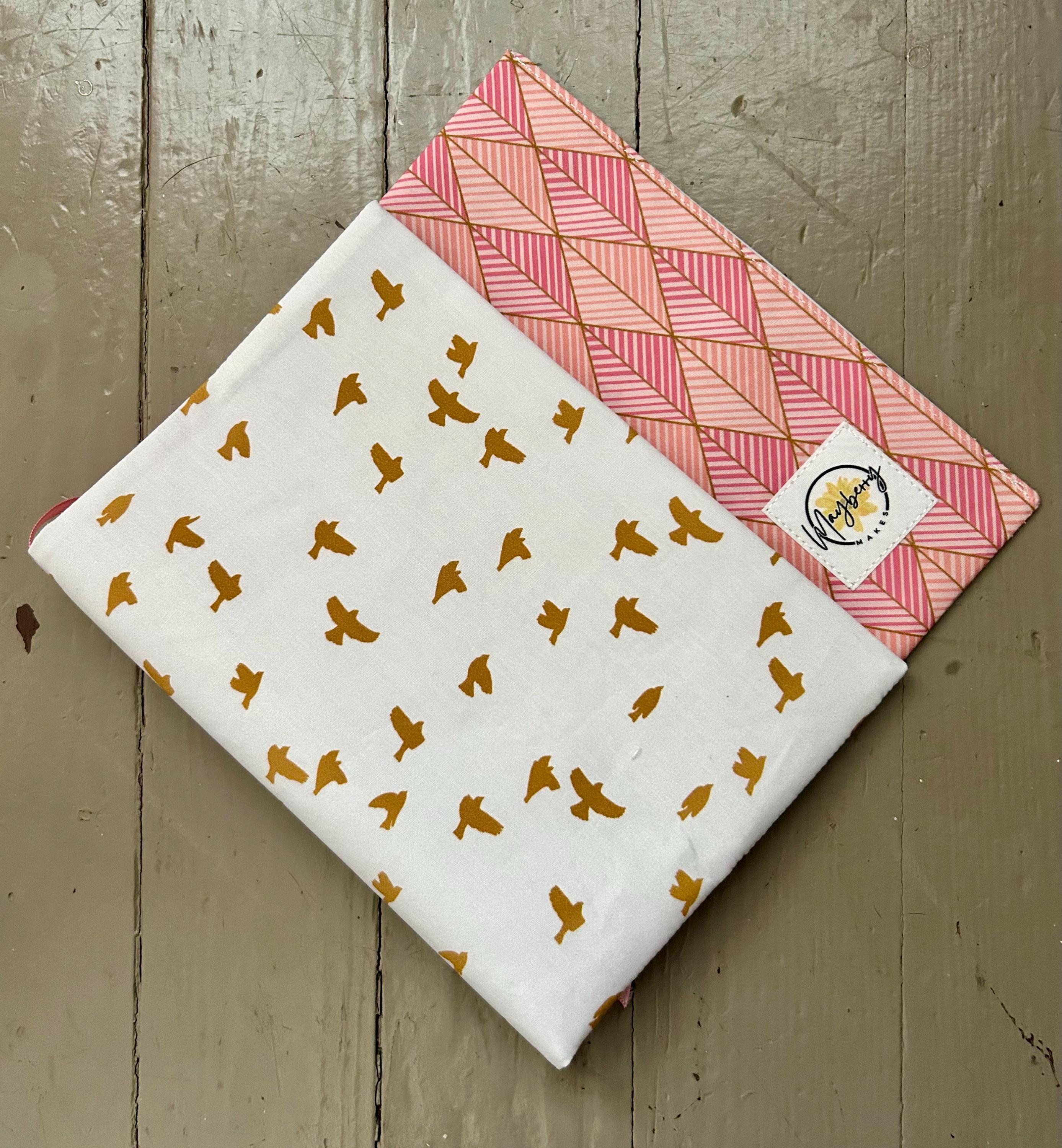 Two fabric swatches with patterns on a wooden surface