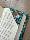Book with a decorative mermaid-themed bookmark on a wooden surface